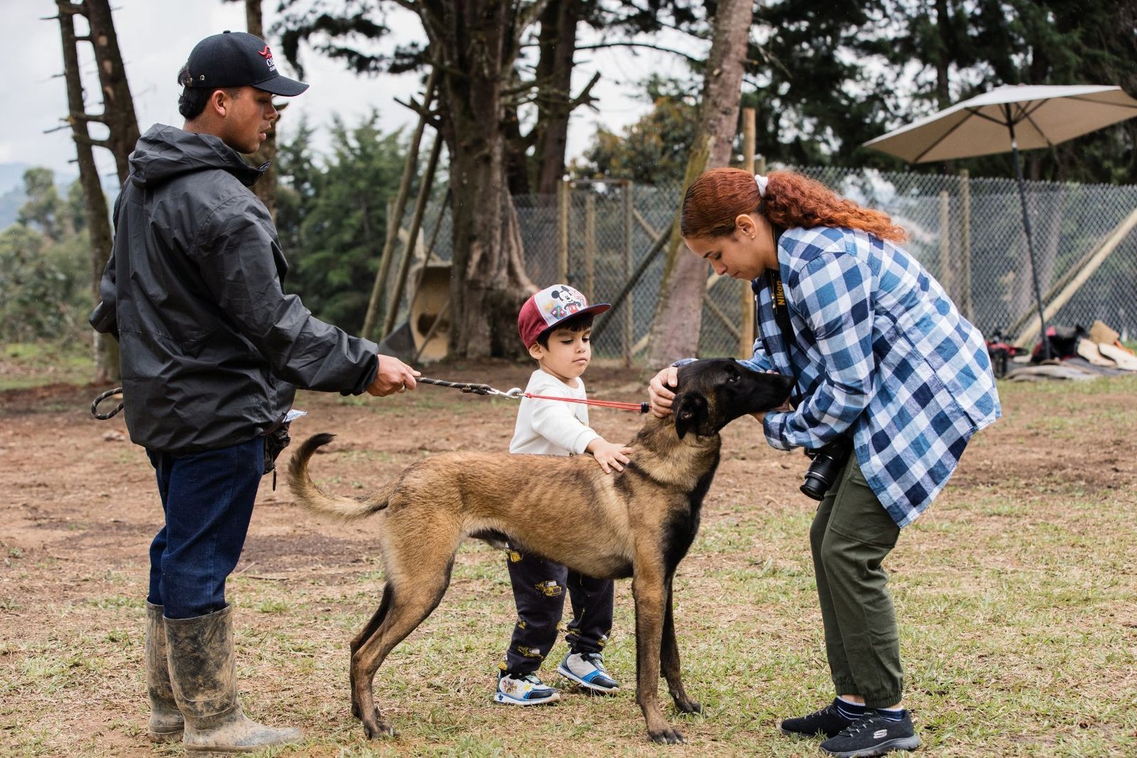 Familia con su perro y el entrenador durante el entrenamiento a domicilio